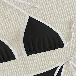 Detailed close-up of color-block bikini top with contrast white piping and ruching detail