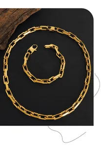 Dettaglio del set collana e bracciale a maglia cubana in oro 18 carati su sfondo nero