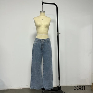 Détail du jean bleu clair à taille haute et jambe large avec bouton et fermeture éclair