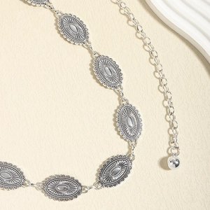 Close-up of vintage silver metal waist chain with oval embossed decorative blocks