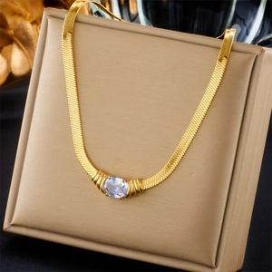 Detail of a gold snake chain necklace with an oval cubic zirconia on a luxury display box