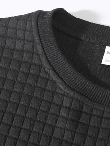 Close-up of black men's sweatshirt showing detailed quilted square pattern texture