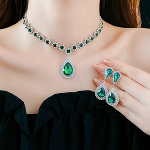 Primo piano della collana argento e orecchini a goccia verde su una modella