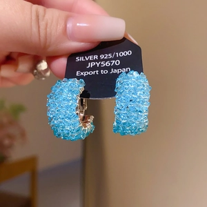 Détail de l'étiquette Argent 925 sur une boucle d'oreille en perles bleues et cristal