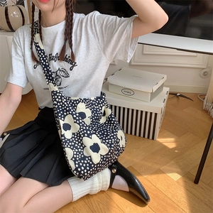 Navy canvas floral crossbody bag shown on model to demonstrate size and drape