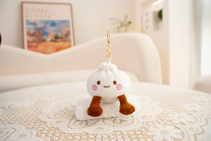 Close-up of a plush bun charm with cute embroidery and dangling brown legs