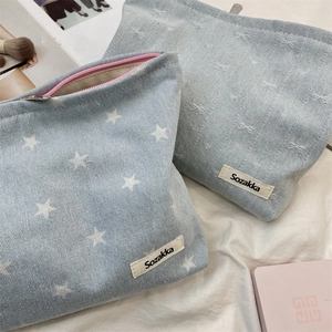 Detail of denim cosmetic bags with star prints and bow jacquard for travel storage