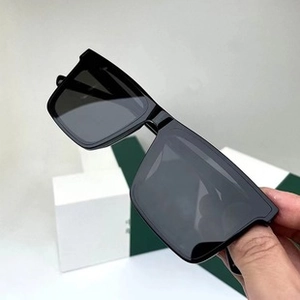 Detail shot of black oversized square sunglasses with dark grey lenses and smooth finish