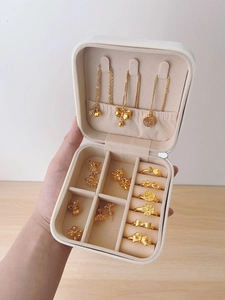Handheld jewelry box detail showing three necklace hooks and ring storage slots