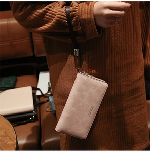 Close-up of matte pink long wallet for women with zipper and Forever Better text