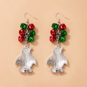Detail of Christmas earrings featuring red and green bells with a silver penguin charm