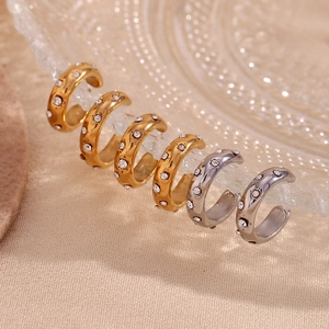 18K gold plated stainless steel C-shaped ear cuffs with zircon accents on a glass dish