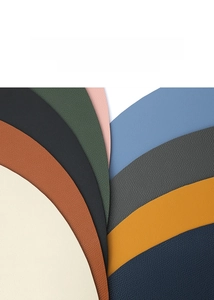 Close-up of multicolored round PU leather placemats showing soft lychee grain texture