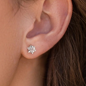 Macro shot of 925 sterling silver six-prong moissanite stud earring on a model ear