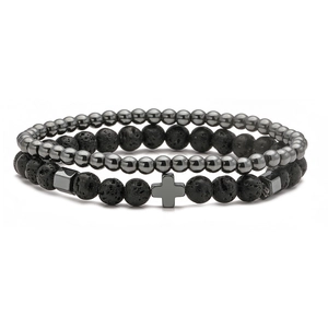 Macro detail of punk set with volcanic lava beads and cross charm on white background