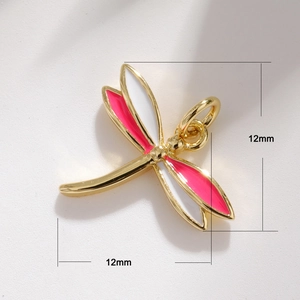Macro view of 12mm gold dragonfly pendant with pink and white enamel wings detail