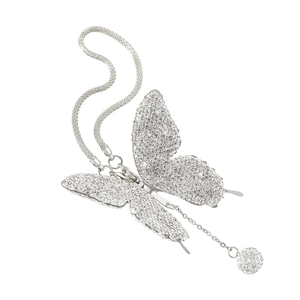 Macro detail of silver butterfly car mirror pendant with shimmering rhinestones