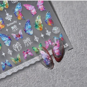 Macro detail of colorful laser butterfly nail stickers with glitter and lace on clear tips