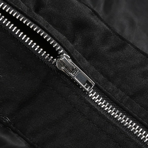 Detailed close-up of metallic silver zipper on black fabric for a stylish bodice top