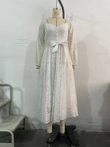 Détail d'une robe élégante en dentelle blanche avec manches lanternes et ruban de taille