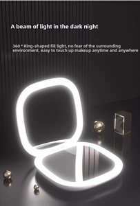 Detailed view of portable LED makeup mirror with 360 ring light on dark background