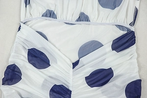 Detailed close-up of blue and white polka dot fabric with elegant pleated fold details