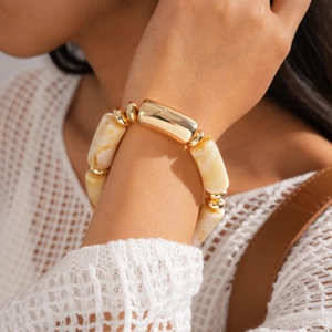 Close-up of bohemian resin marble pattern bracelet with gold-tone metal accents on wrist