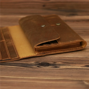 Macro view of vintage brown leather wallet showing card slots and premium texture