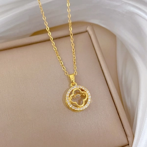 Macro detail of gold plated four-leaf clover pendant with pavé cubic zirconia inlay