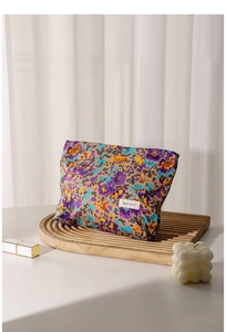 Macro view of floral cosmetic bag with colorful flowers on a wavy wooden tray