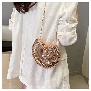 Unique rose gold snail-shaped evening bag with a metallic chain strap on model