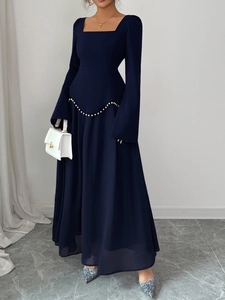 Détail de robe de soirée bleu marine élégante avec ceinture en perles et manches longues