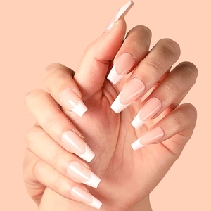 French tip long coffin press-on nails in nude pink and white on a peach background