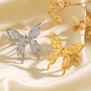 Fashion minimalist butterfly rings in gold and silver finish on silk fabric with dried flowers