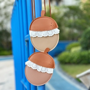 Detail of acorn-shaped leather crossbody bag with lace trim and soft lychee texture