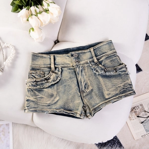 Detailansicht der High-Waist Denim Shorts mit silbernen Nieten und ausgefransten Säumen
