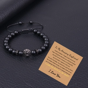 Men's matte black stone bracelet with lion head charm on a romantic gift message card