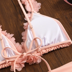 Detail of pink mesh petal embroidery and adjustable straps on bikini top
