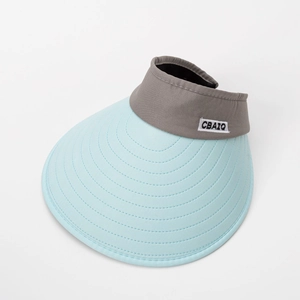 Gros plan d'une visière avec bord bleu et bandeau gris orné d'une broderie CBAIQ