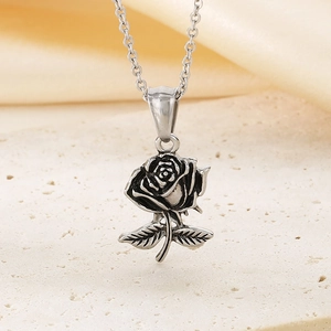 Vue détaillée du collier pendentif rose en argent vieilli sur une pierre beige