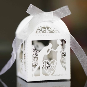 Laser-cut white wedding favor box featuring bride and groom silhouette with a silk ribbon