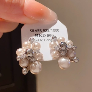 Detailed macro view of S925 silver stud earrings with clustered pink pearls and metal spheres