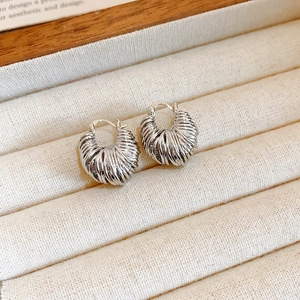 Macro shot of silver twisted hoop earrings with textured finish in a velvet jewelry box