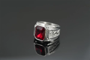 Close-up of vintage dragon relief engraving and red rectangular gemstone on silver ring