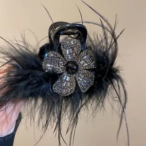 Pince à cheveux en acrylique avec plumes noires et détails de fleurs en strass