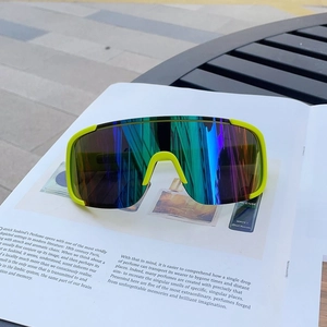 Outdoor sports sunglasses with neon green frame and rainbow lens on a magazine
