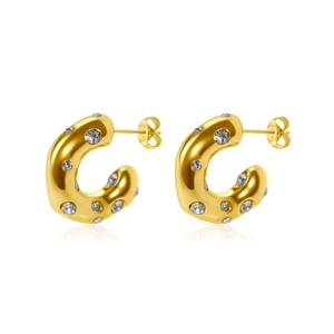 Detailed view of C-shaped gold earrings featuring inlaid zircon stones and pearls on white