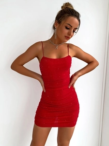 Detail of red sequin backless mini dress with spaghetti straps and pleated fabric texture