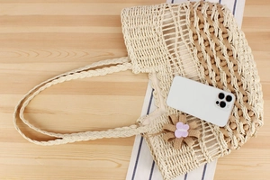 Close-up of bohemian woven tote bag with hollow mesh pattern and floral charm detail