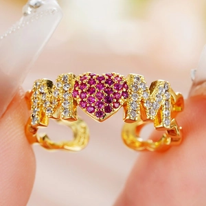 Macro shot of gold MOM heart ring featuring purple cubic zirconia and crystal pavé details